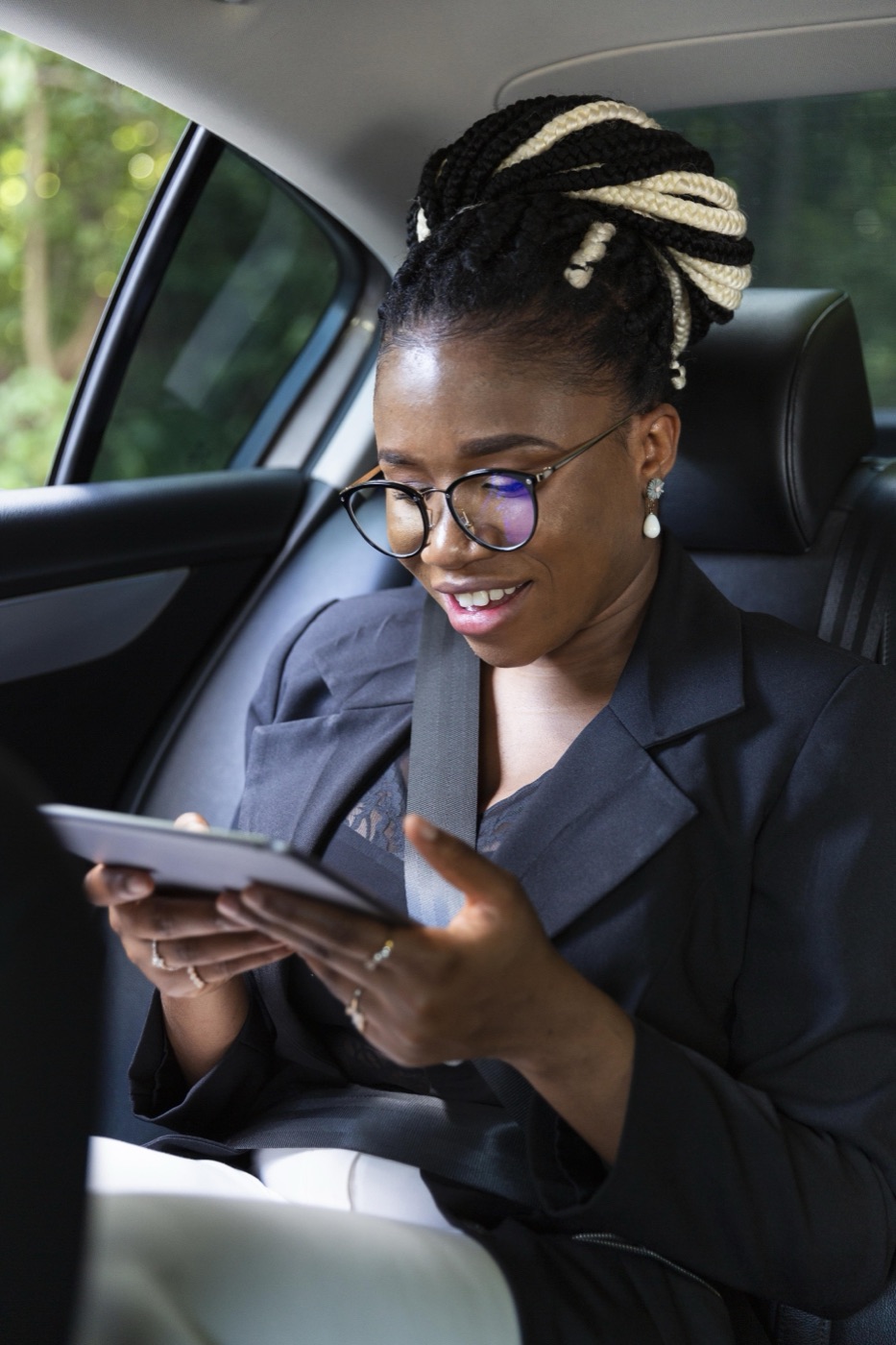 A rider wearing her seatbelt, relaxed in the back seat